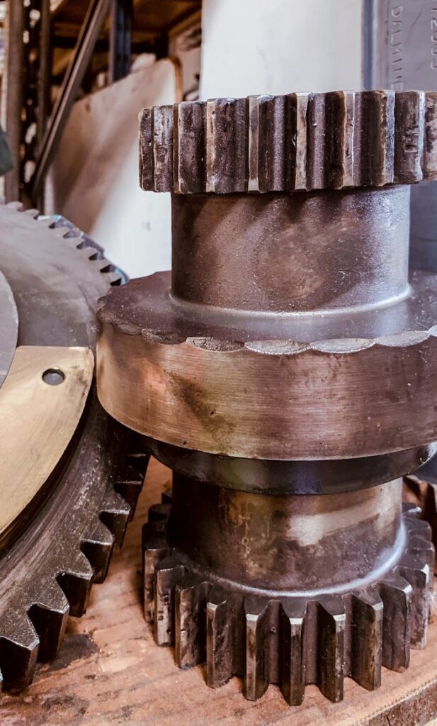 Detailed view of heavy iron gears on a workshop table, highlighting industrial equipment.